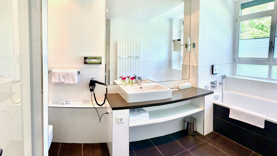 In zwei von unseren Komfort Plus-Zimmern: Dusche und Badewanne in einem Bad mit Tageslicht sowie viel Ablageflächen.